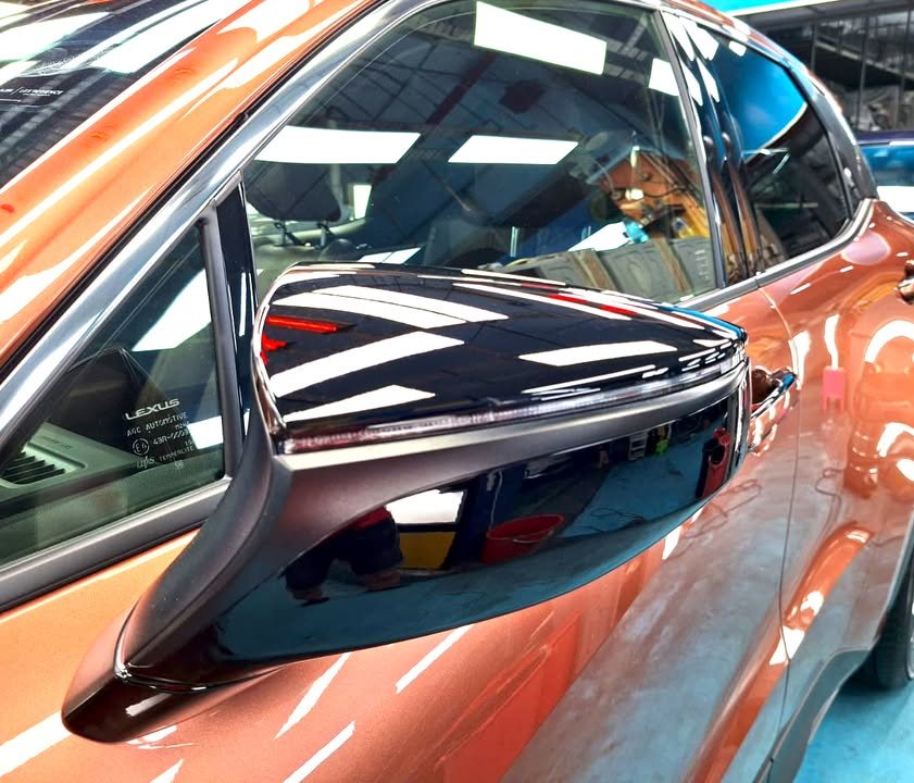 Gloss black door mirror on the copper Lexus LBX.