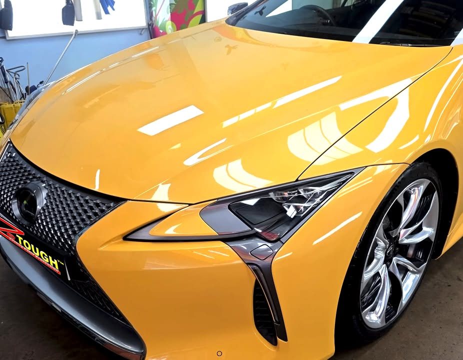 Yellow bonnet and front wing of the LC 500 reflecting the workshop lights, with the spindle grille.