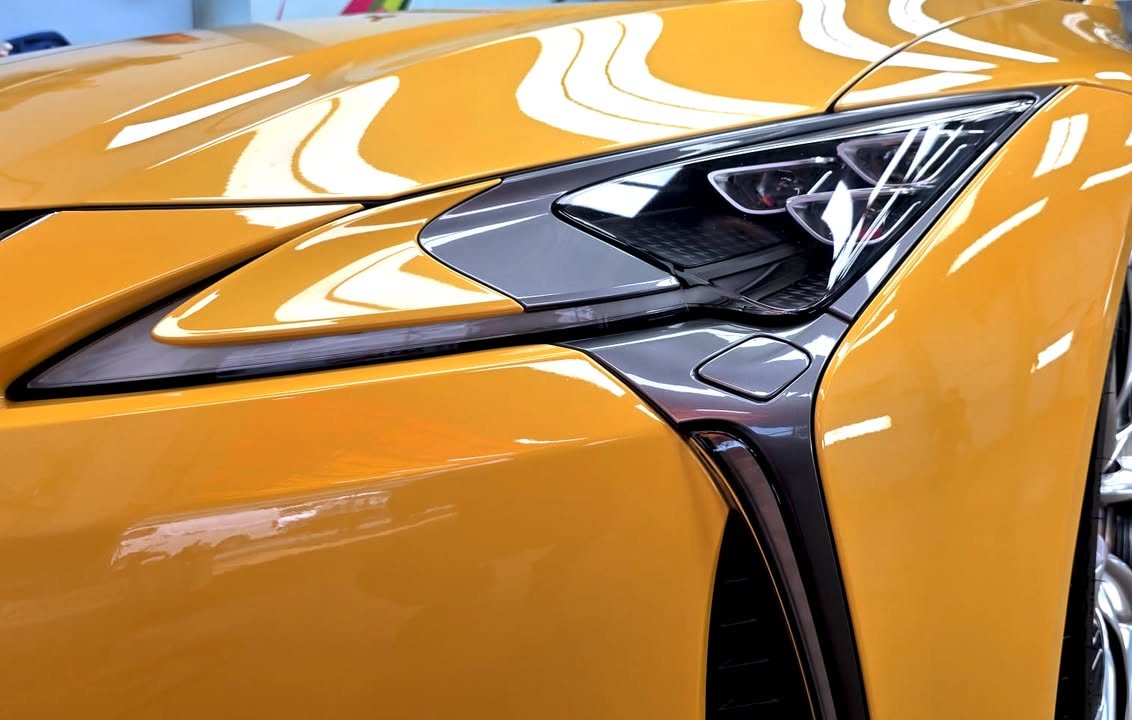 Close-up of the LC 500 headlamp set into the yellow front wing.