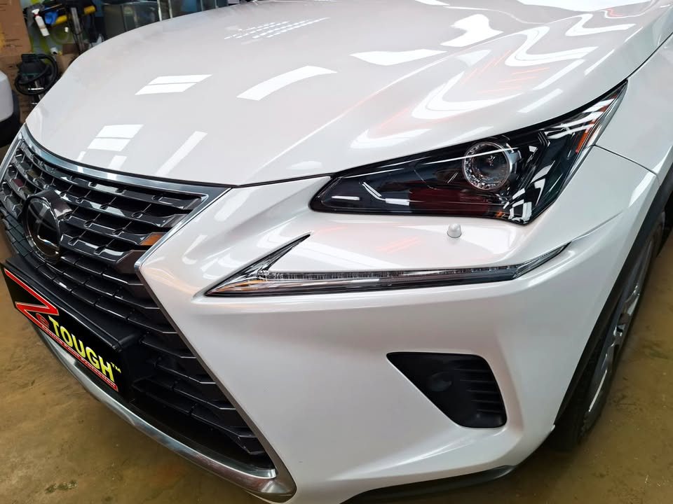 Spindle grille and headlight of the white Lexus NX200t.