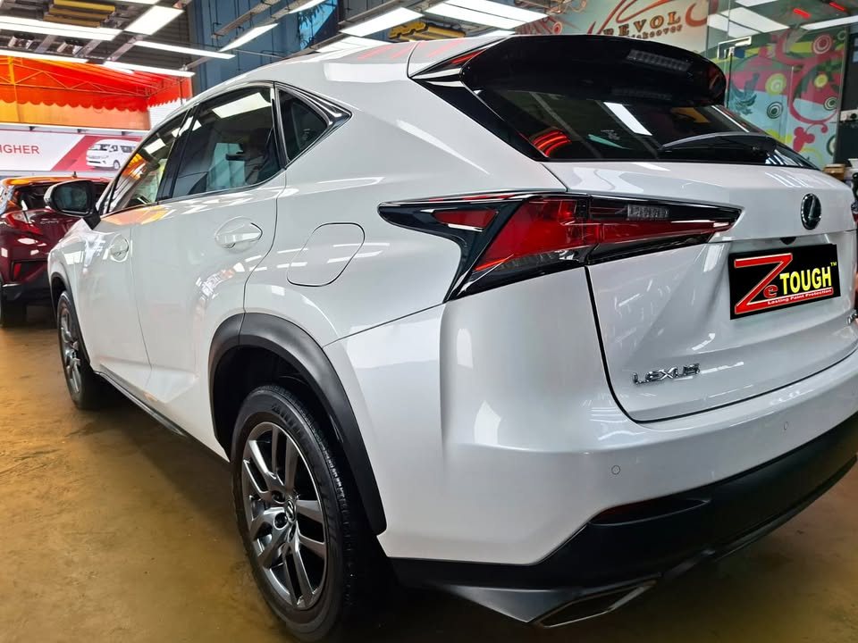 Rear three-quarter view of the white Lexus NX200t with a ZeTough plate.