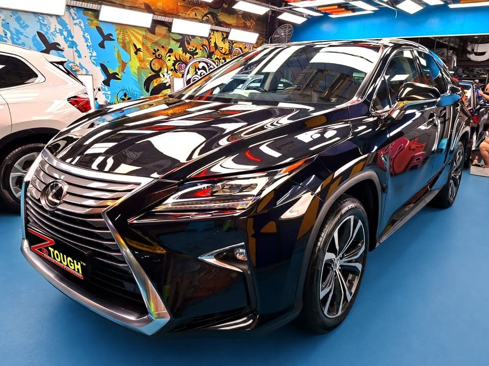Black Lexus RX 200t, front three-quarter view, with workshop lights reflected on the bonnet after its ZeTough Ceramic coating.