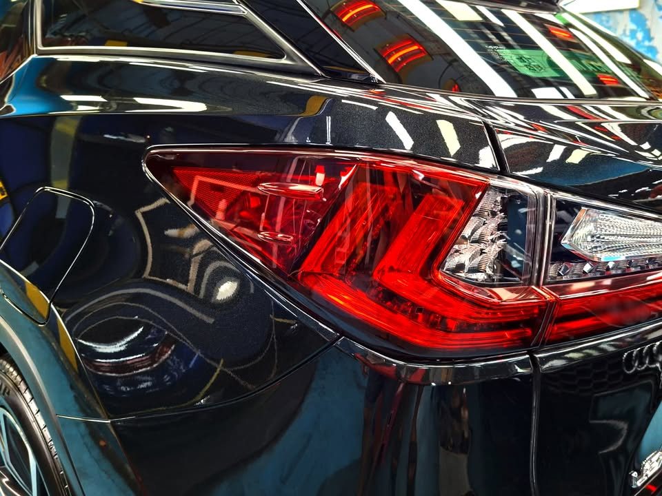 Close-up of the red Lexus tail light on the black rear quarter.