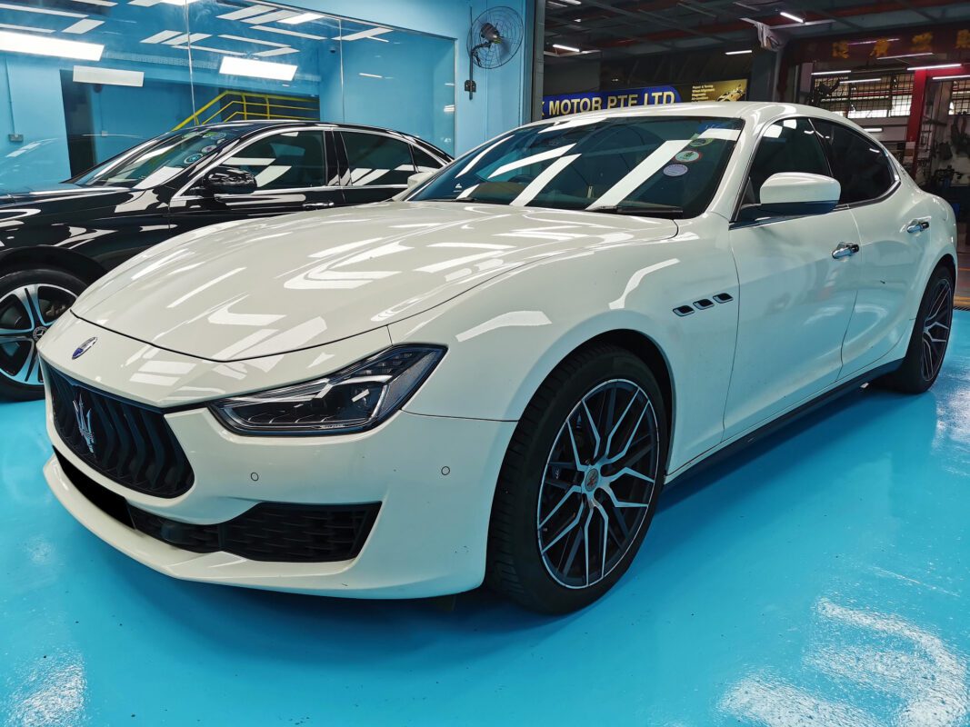 The Maserati Ghibli as it arrived at Revol Carz, showing scratches and paint peeling across multiple panels.