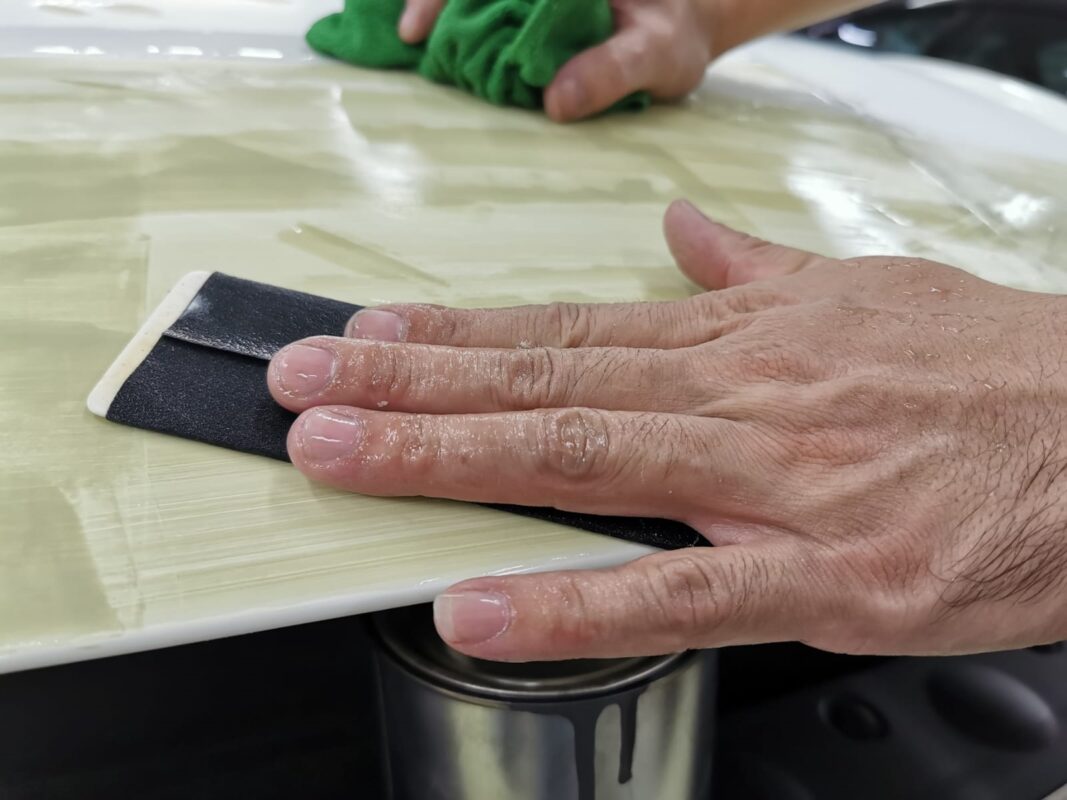 Wet-sanding the Maserati Ghibli's surface to create a smooth, level foundation.