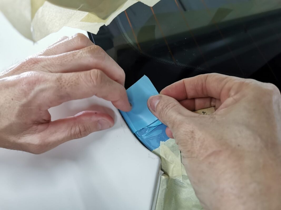 Masking tape applied along trim lines on the Maserati Ghibli ahead of spraying.