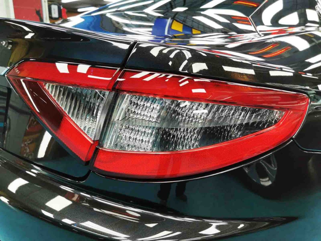 The coated bonnet of the Maserati GranTurismo under workshop lighting.
