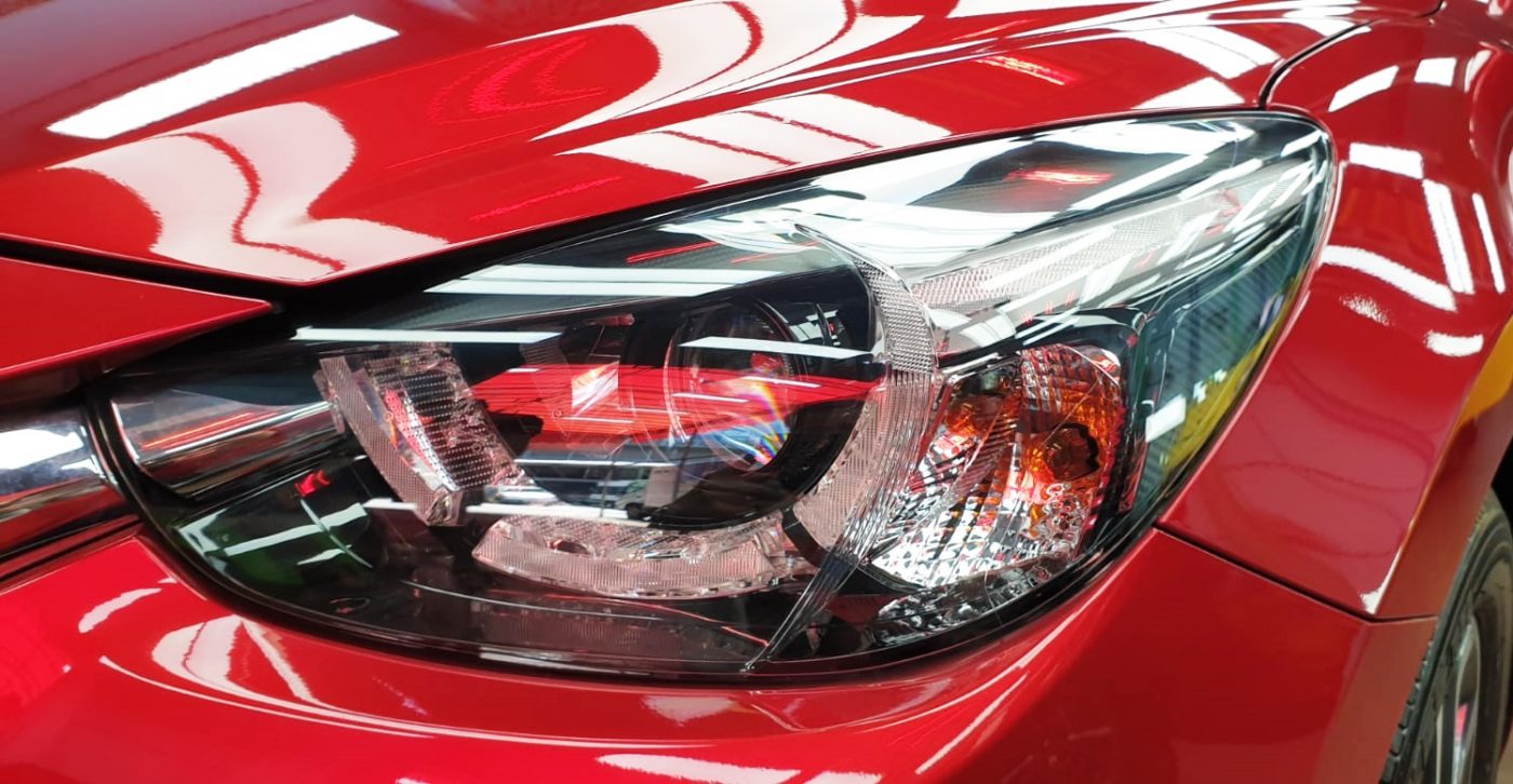 The Mazda 2's coated paintwork showing clean reflections.