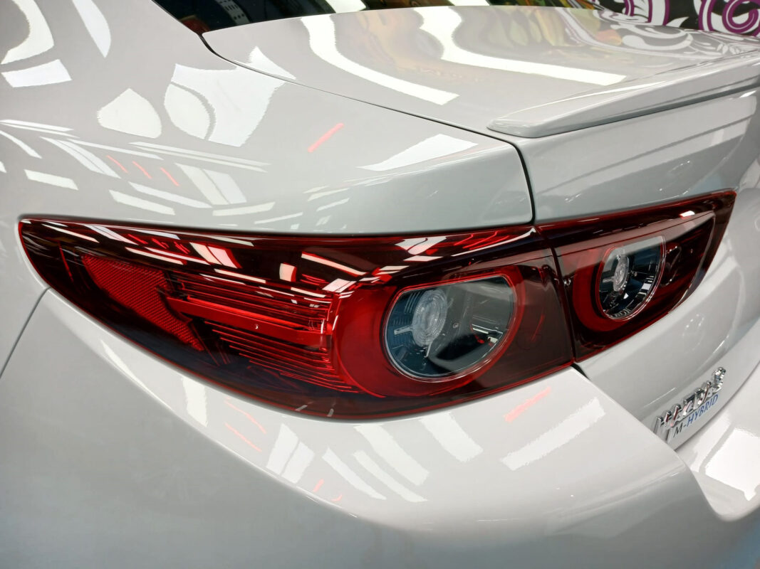 The coated bonnet of the Mazda 3 under workshop lighting.