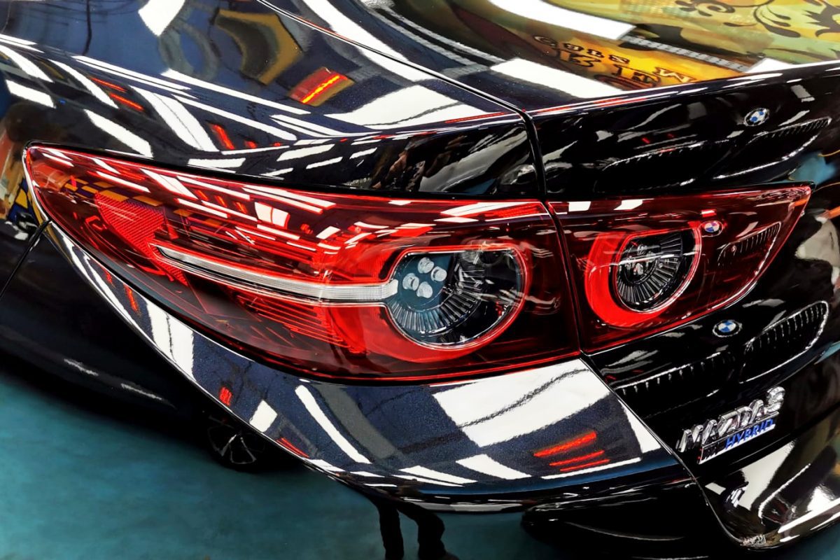 The coated bonnet of the Mazda 3 under workshop lighting.
