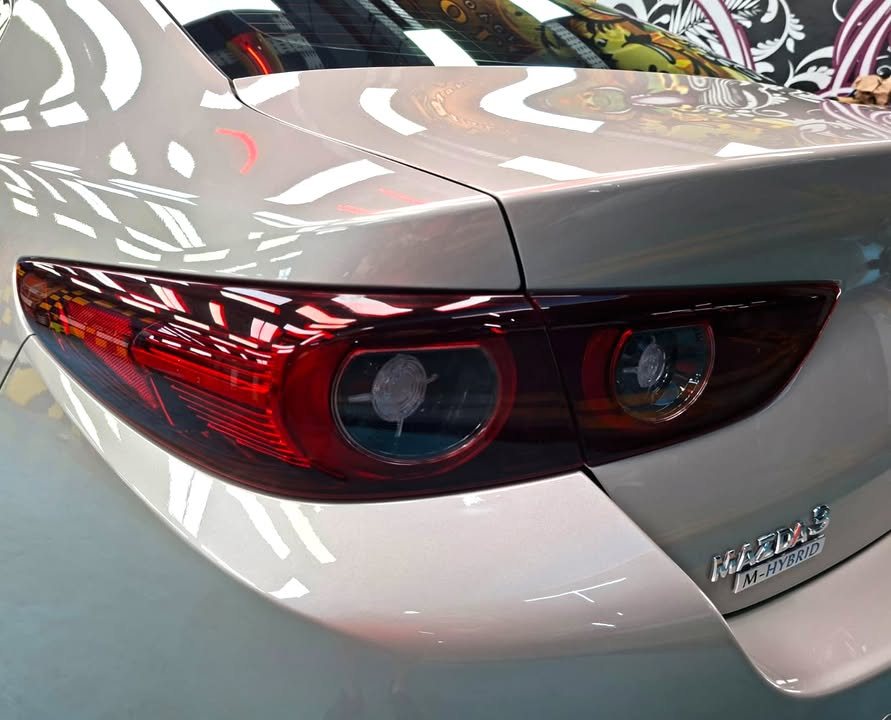 Close-up of the round tail light and badge on the silver boot lid.