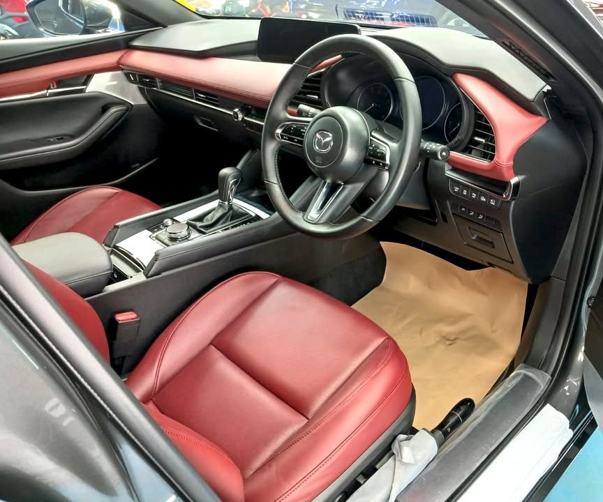 Interior with red leather seats, black steering wheel and red dashboard trim.