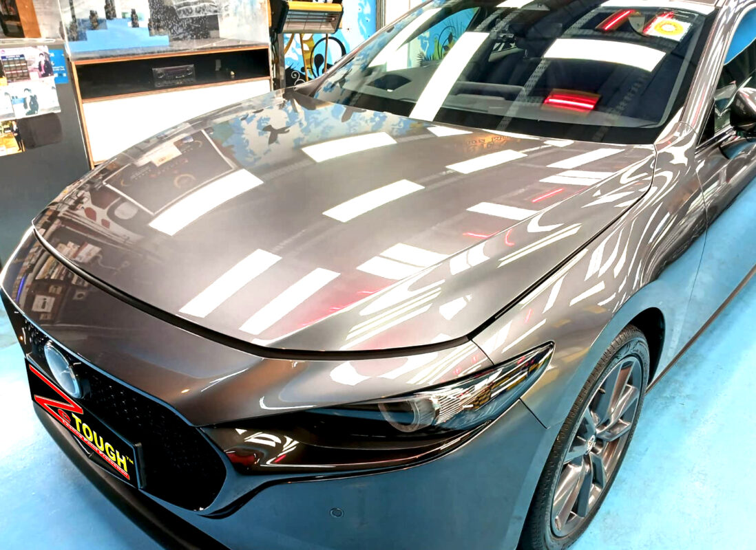 The Mazda 3's coated paintwork under workshop lighting.