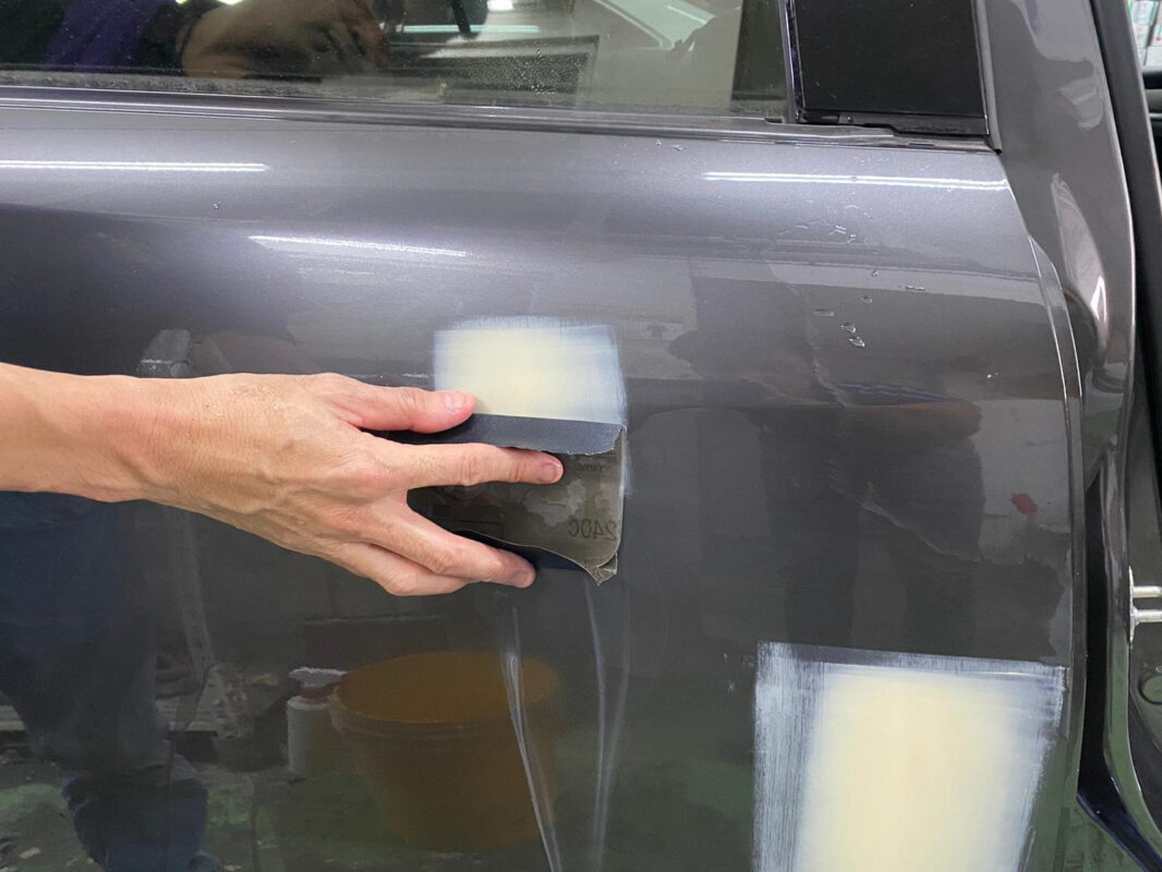 Wet-sanding the Mazda 6 panels on day four to create a smooth, level surface.