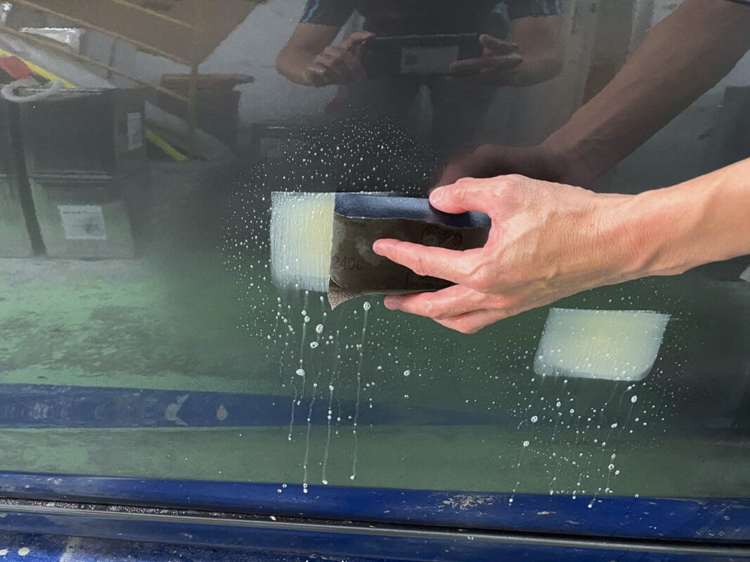 Masking off non-painted surfaces on the Mazda 6 before the spray booth.