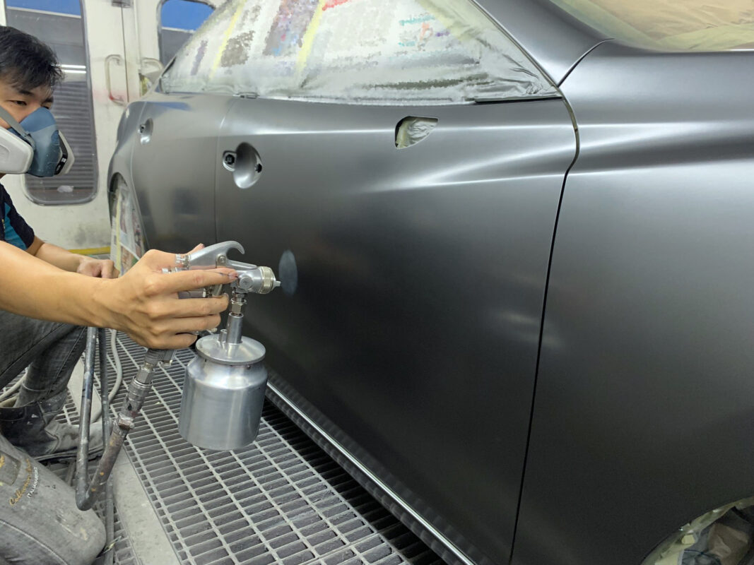 Sanding the freshly baked paint on the Mazda 6 on day six.