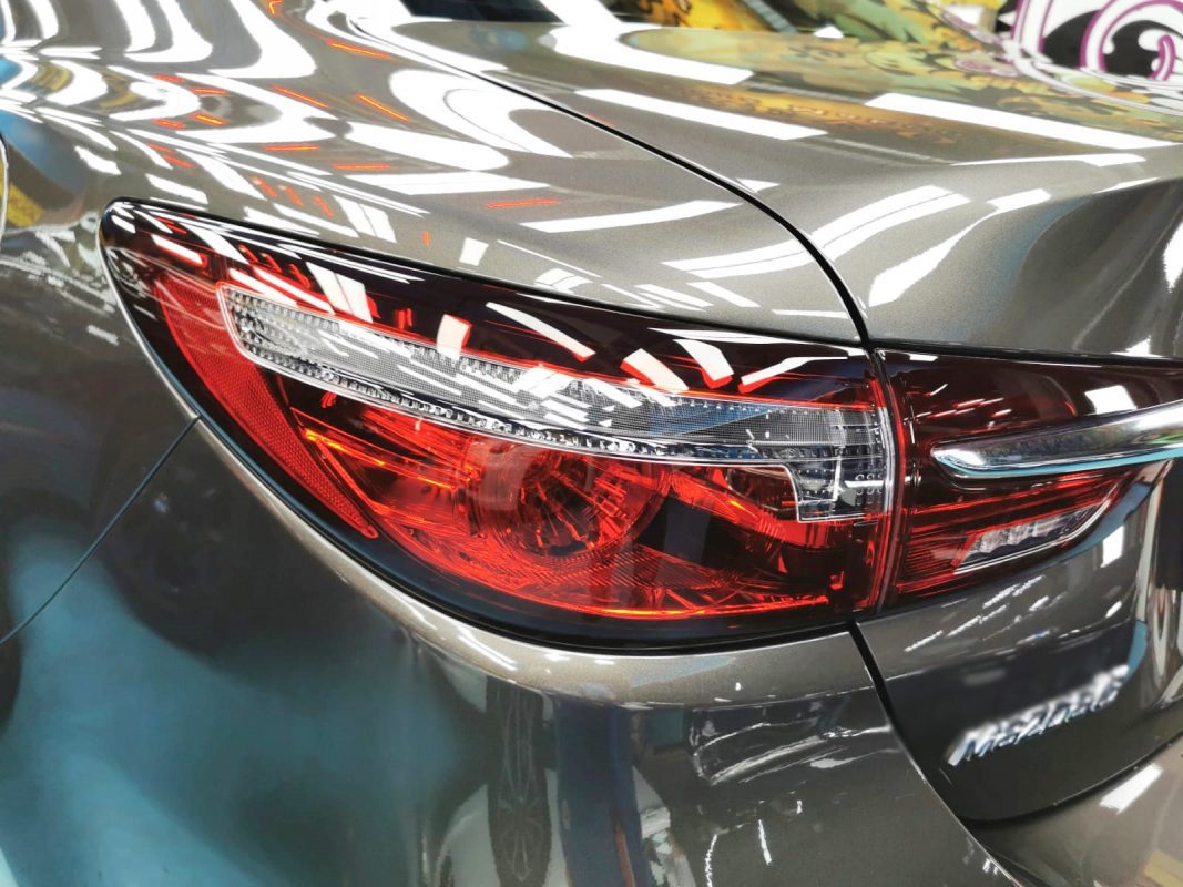 The coated bonnet of the Mazda 6 under workshop lighting.