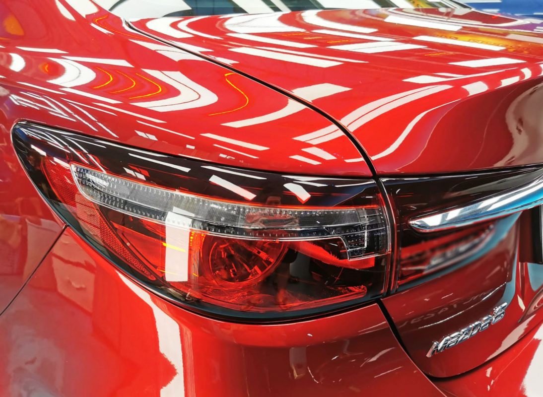 The coated bonnet of the Mazda 6 under workshop lighting.