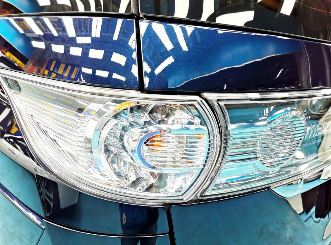 The coated bonnet of the Mazda Biante under workshop lighting.