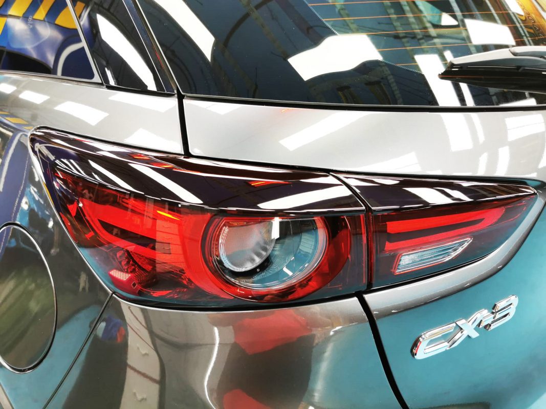 The coated bonnet of the CX-3 under workshop lighting.