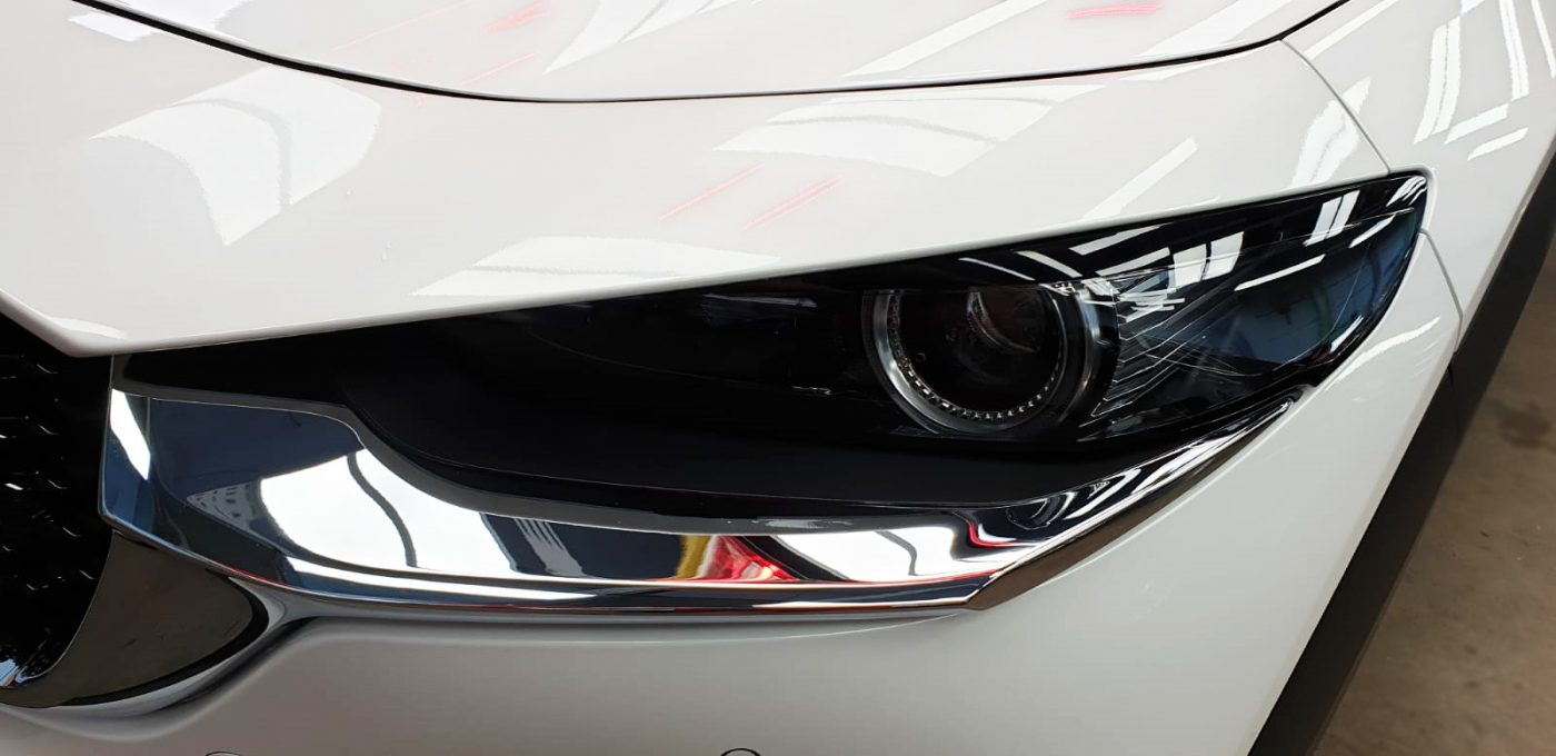 The CX-30's coated paintwork showing clean reflections.