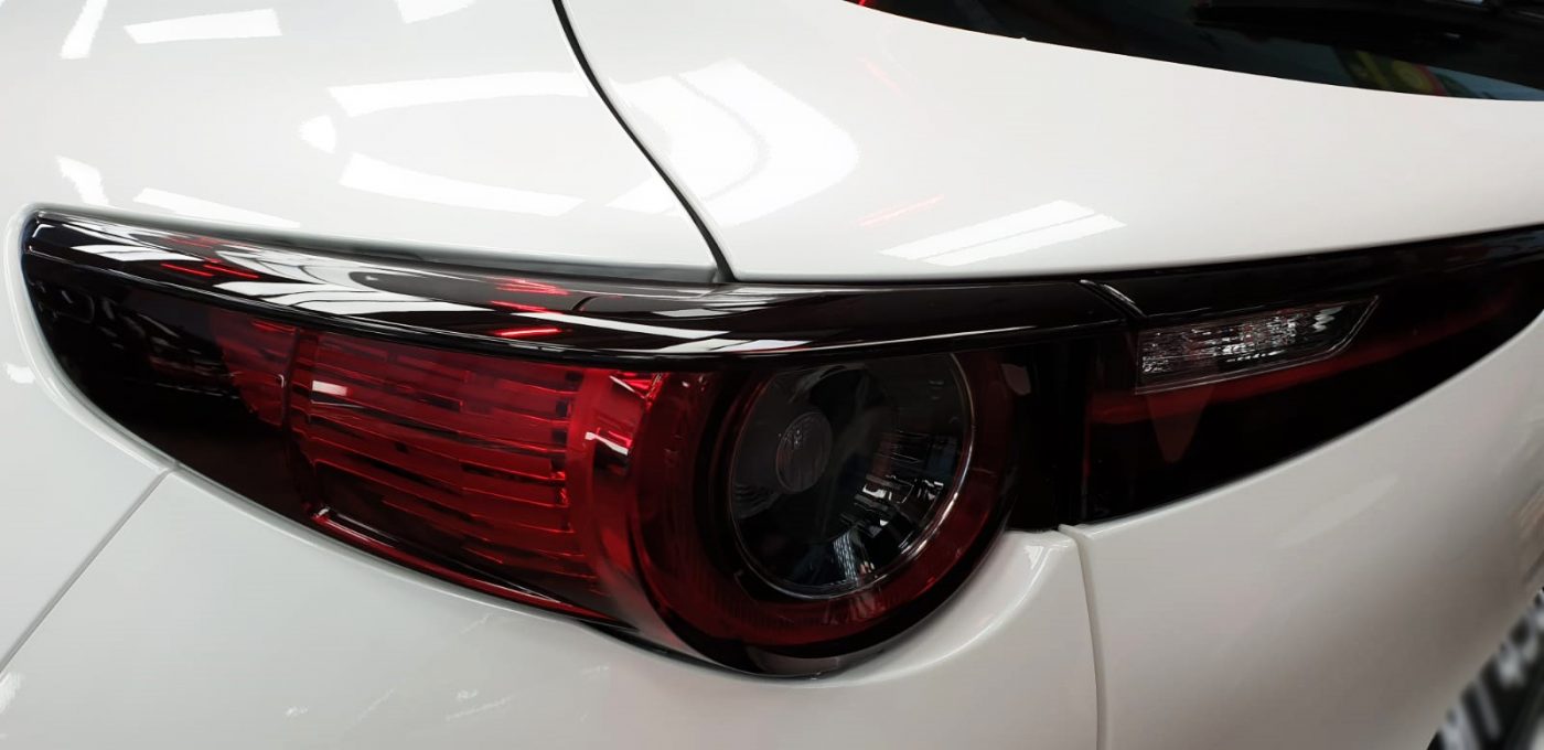 The coated bonnet of the CX-30 under workshop lighting.