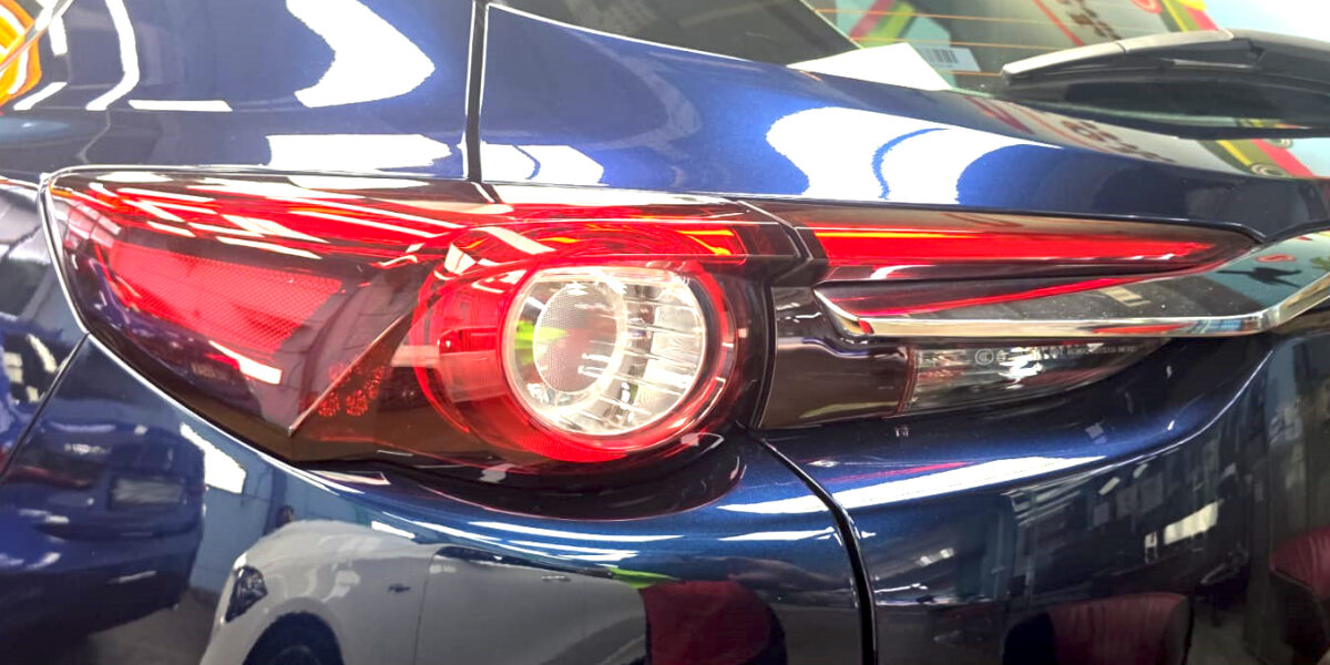 The coated bonnet of the Mazda CX-9 under workshop lighting.