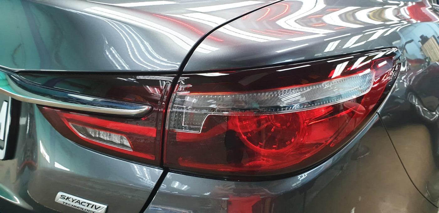 The coated bonnet of the Mazda 6 under workshop lighting.