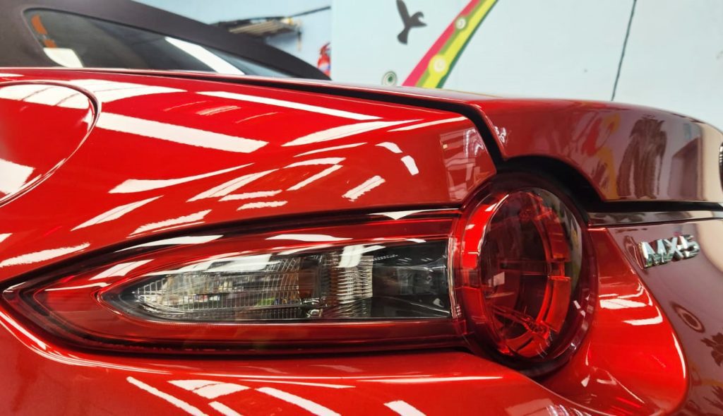 The coated bonnet of the Mazda MX-5 under workshop lighting.