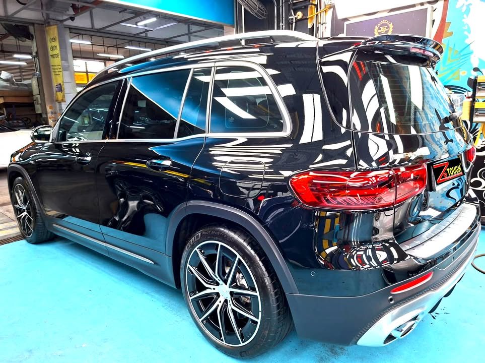 Black Mercedes-AMG GLB 35, rear three-quarter view, in the workshop.
