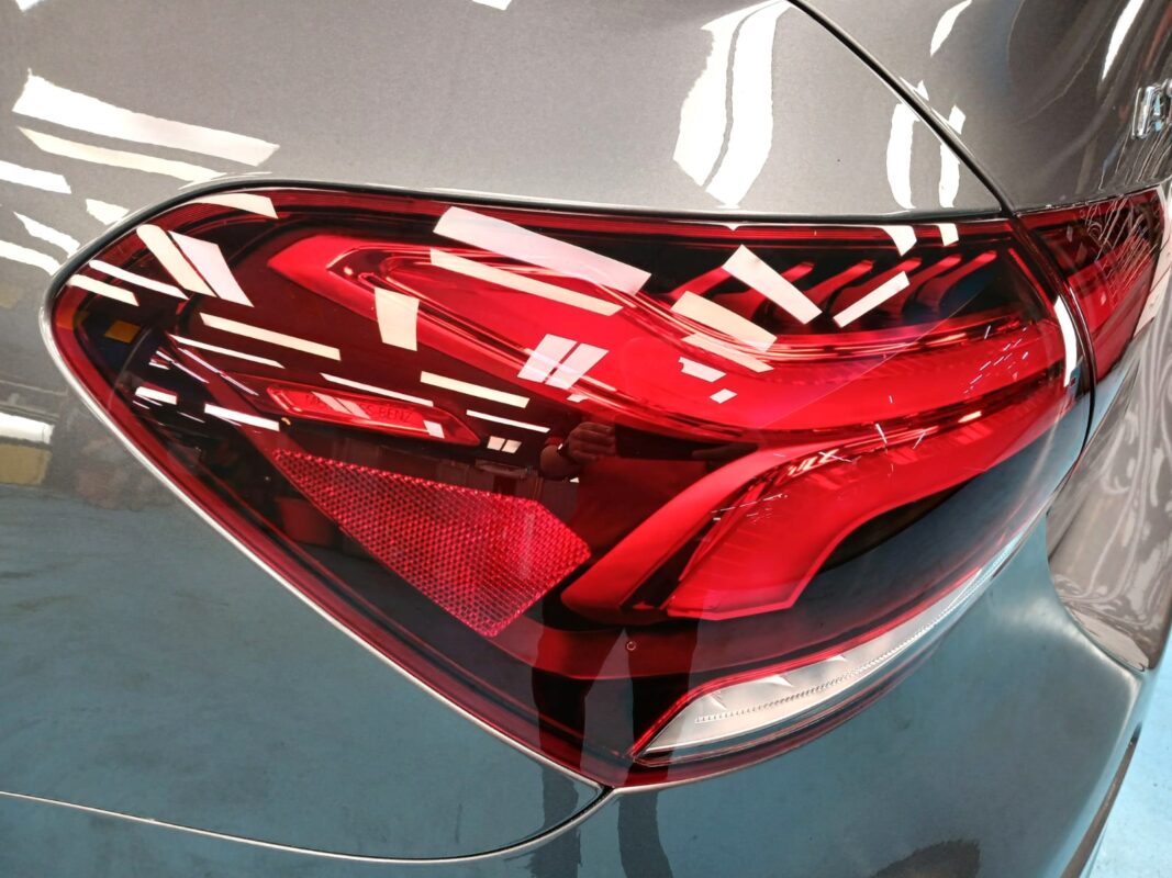 The coated bonnet of the Mercedes-Benz A180 under workshop lighting.