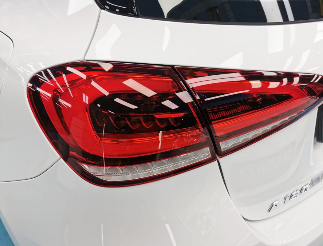The coated bonnet of the Mercedes-Benz A180 under workshop lighting.