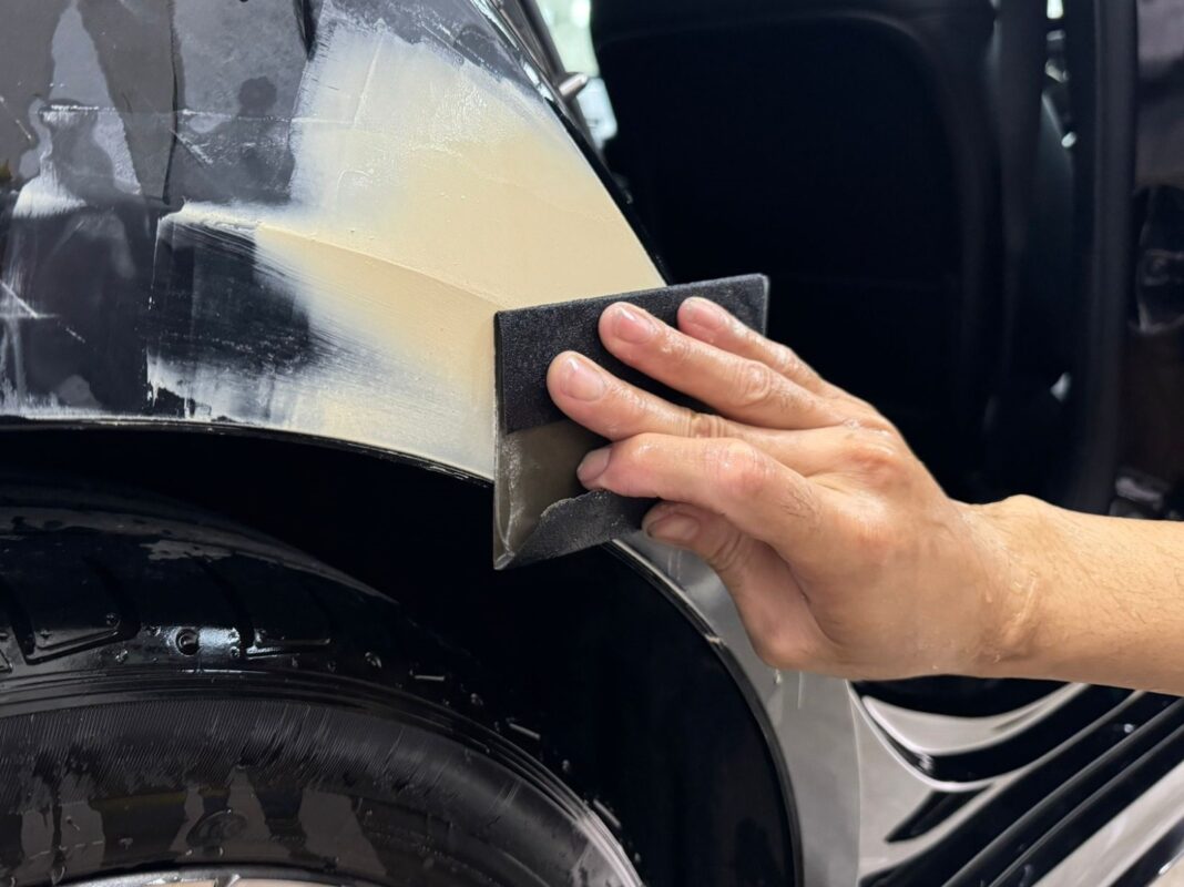 Wet-sanding the A180's panels to achieve an even, smooth surface before priming.