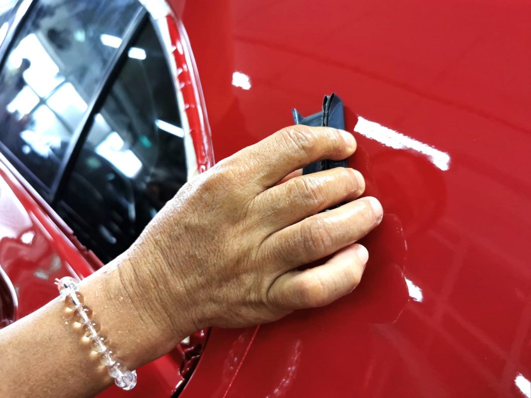 Machine-polishing the newly painted surface of the Mercedes-Benz A180 to bring up the gloss.