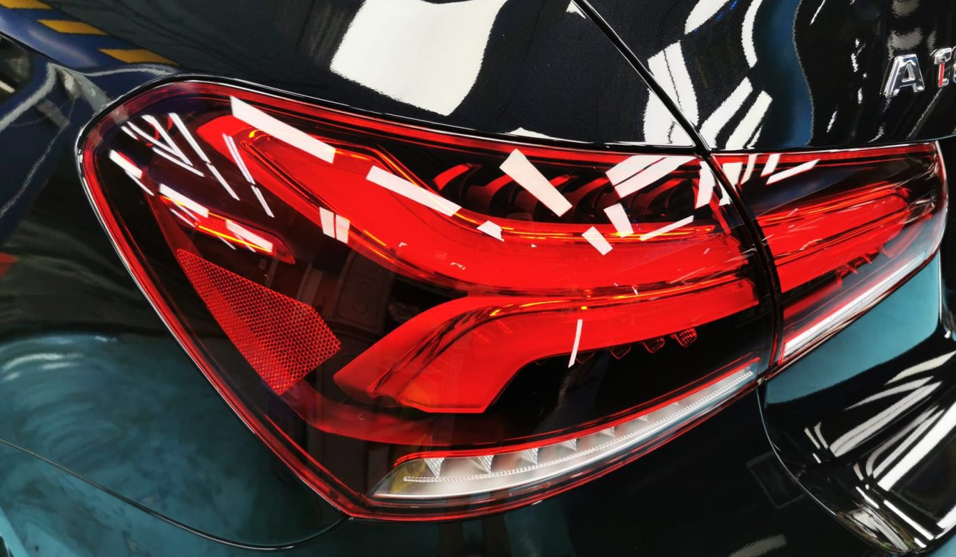 The coated bonnet of the Mercedes-Benz A180 under workshop lighting.