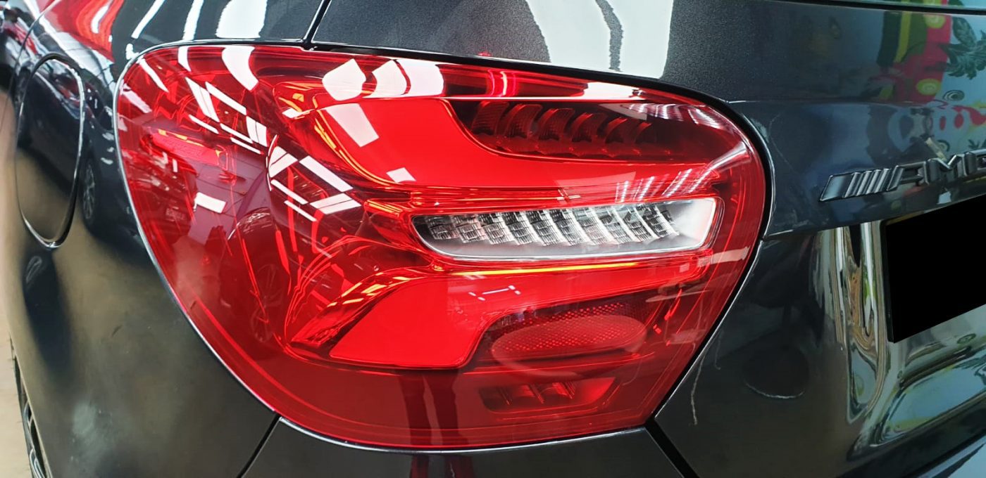 The coated bonnet of the Mercedes-Benz A45 under workshop lighting.
