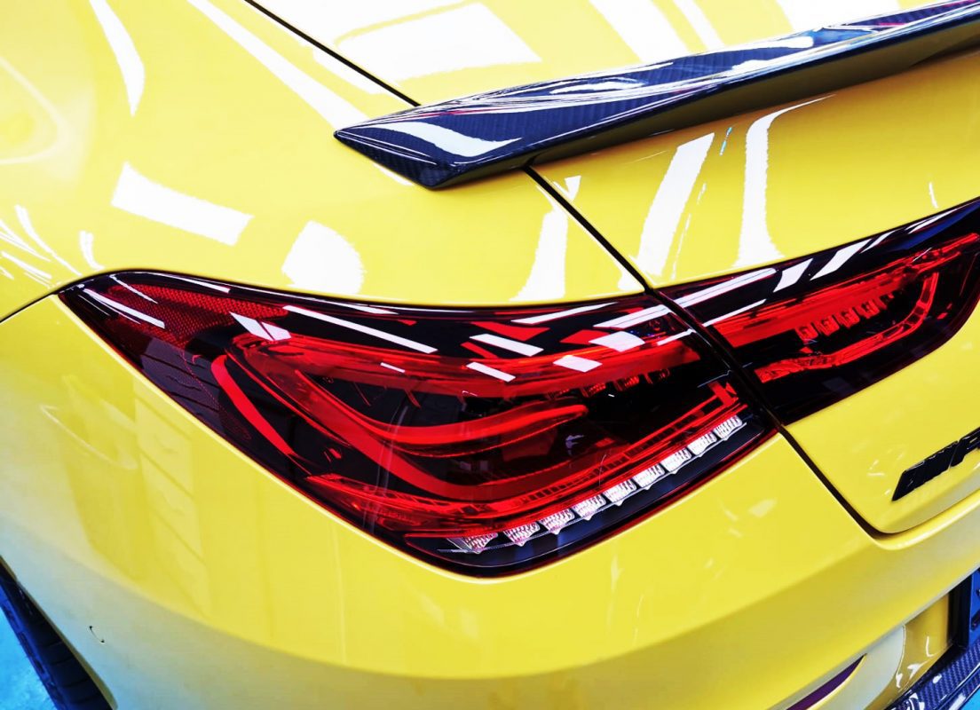 The coated bonnet of the Mercedes-Benz AMG CLA45S under workshop lighting.