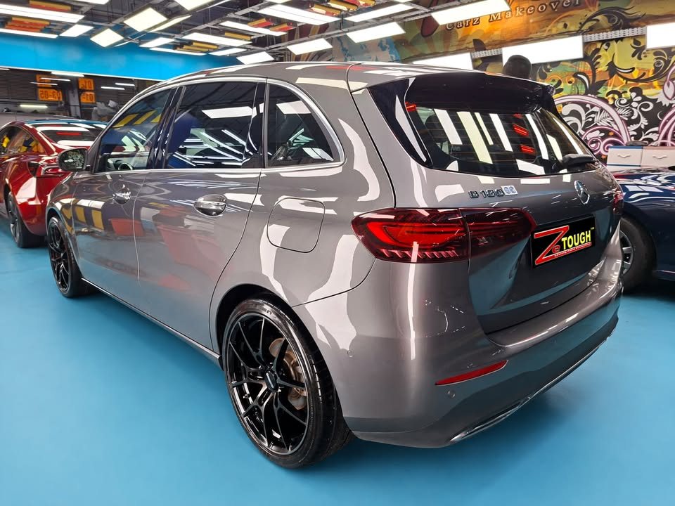 Rear three-quarter view of the grey Mercedes-Benz B 180 showing the tail lights and black wheels.