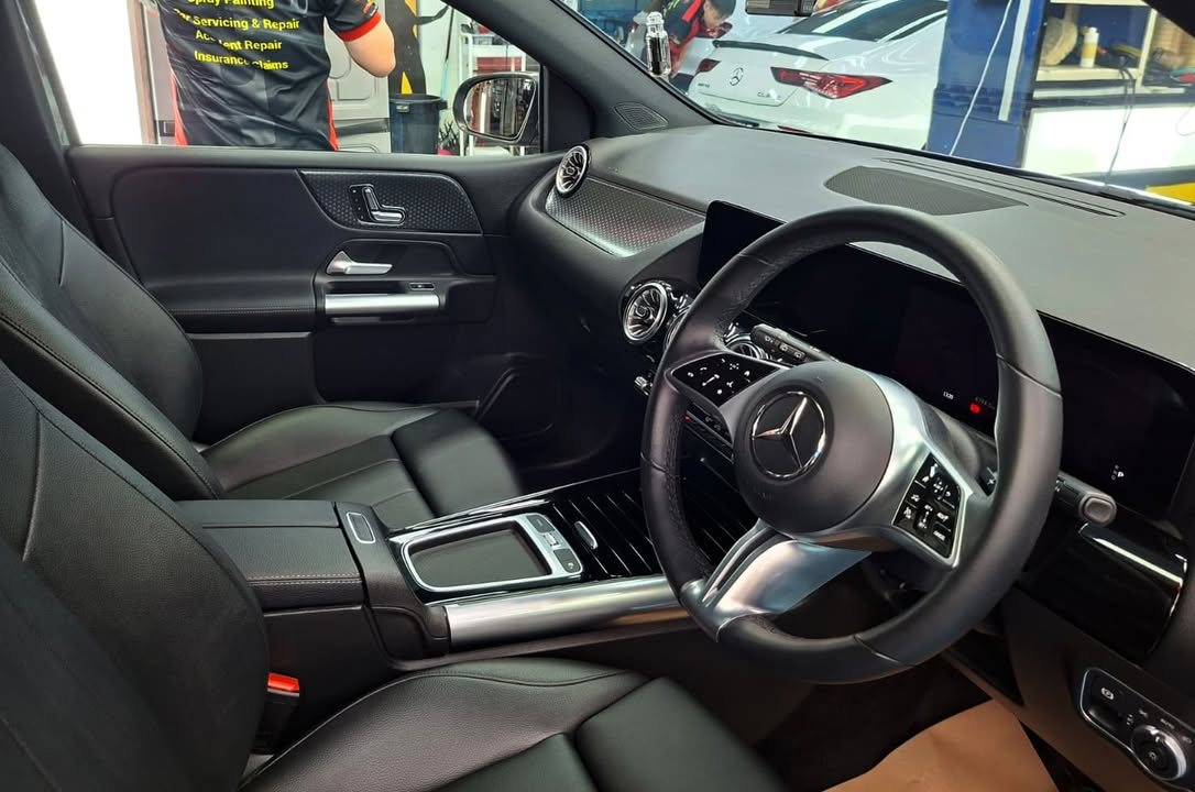 Interior of the Mercedes-Benz B 180 with black seats, steering wheel and dashboard.