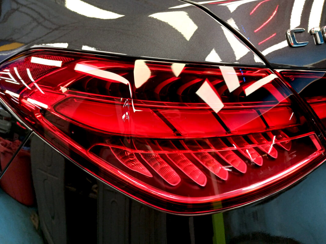 The coated bonnet of the Mercedes-Benz C180 under workshop lighting.