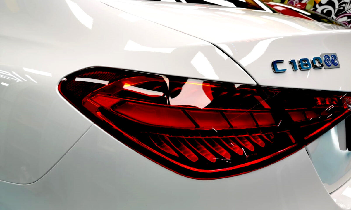 The coated bonnet of the Mercedes-Benz C180 under workshop lighting.