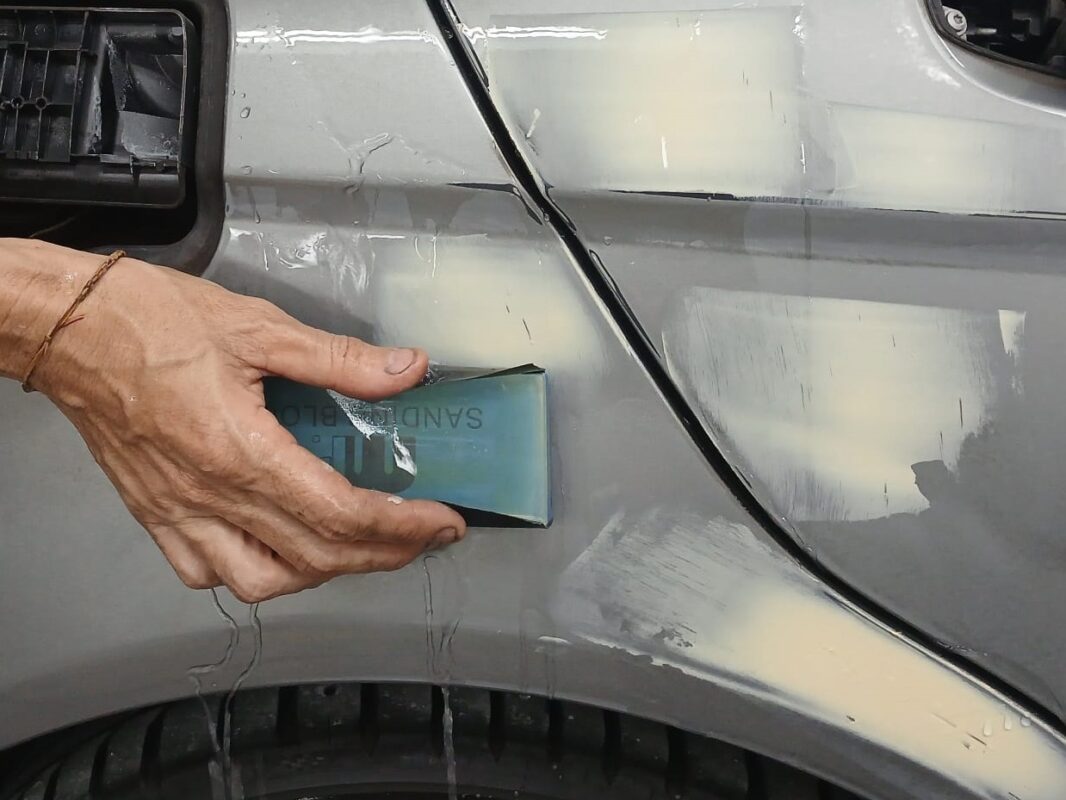 Masking the C180 with paper before entering the spray booth.
