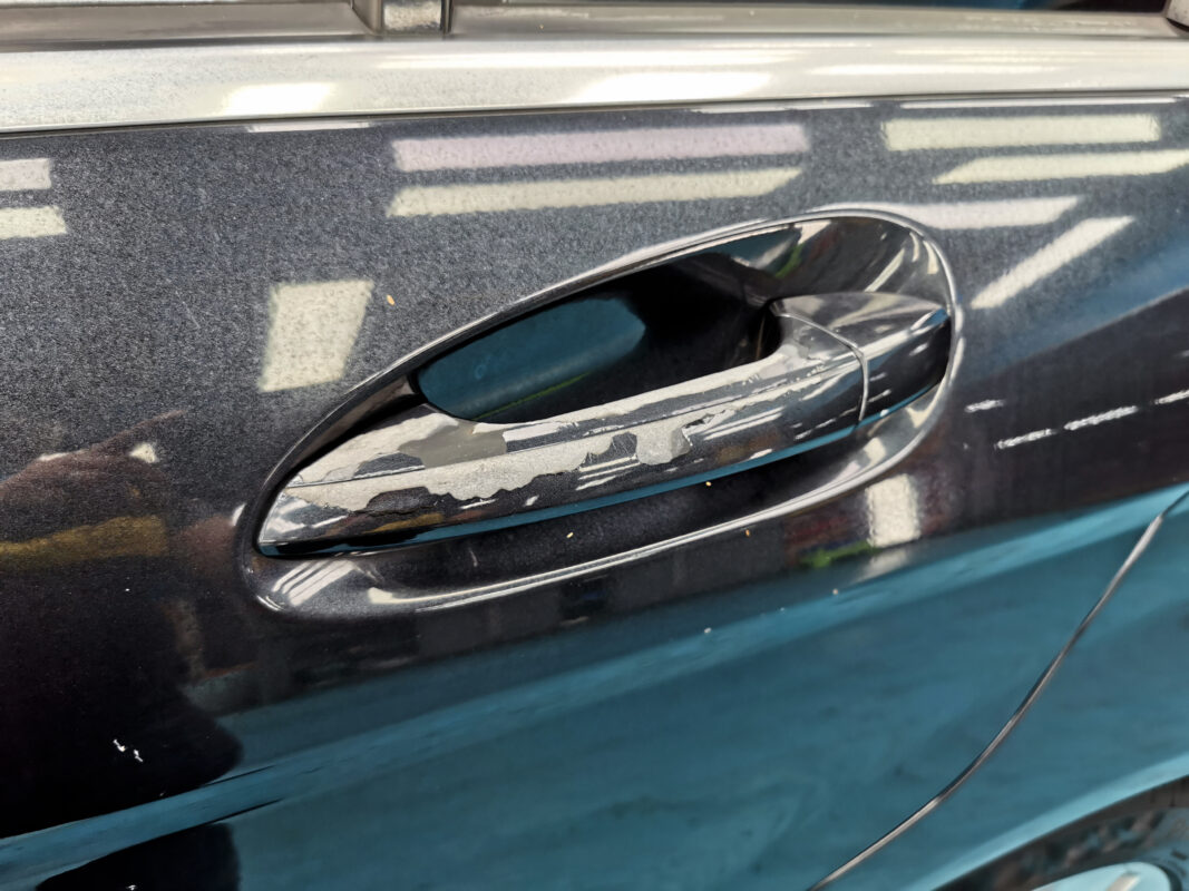A detail shot of the C180's bodywork showing stone chips and surface scratches before the respray.