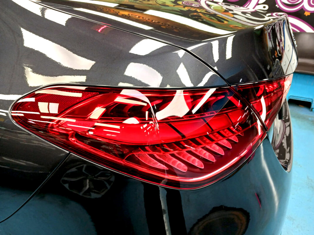 The coated bonnet of the Mercedes-Benz C180 under workshop lighting.