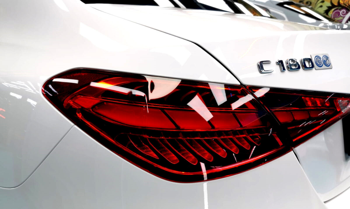 The coated bonnet of the Mercedes-Benz C180 under workshop lighting.