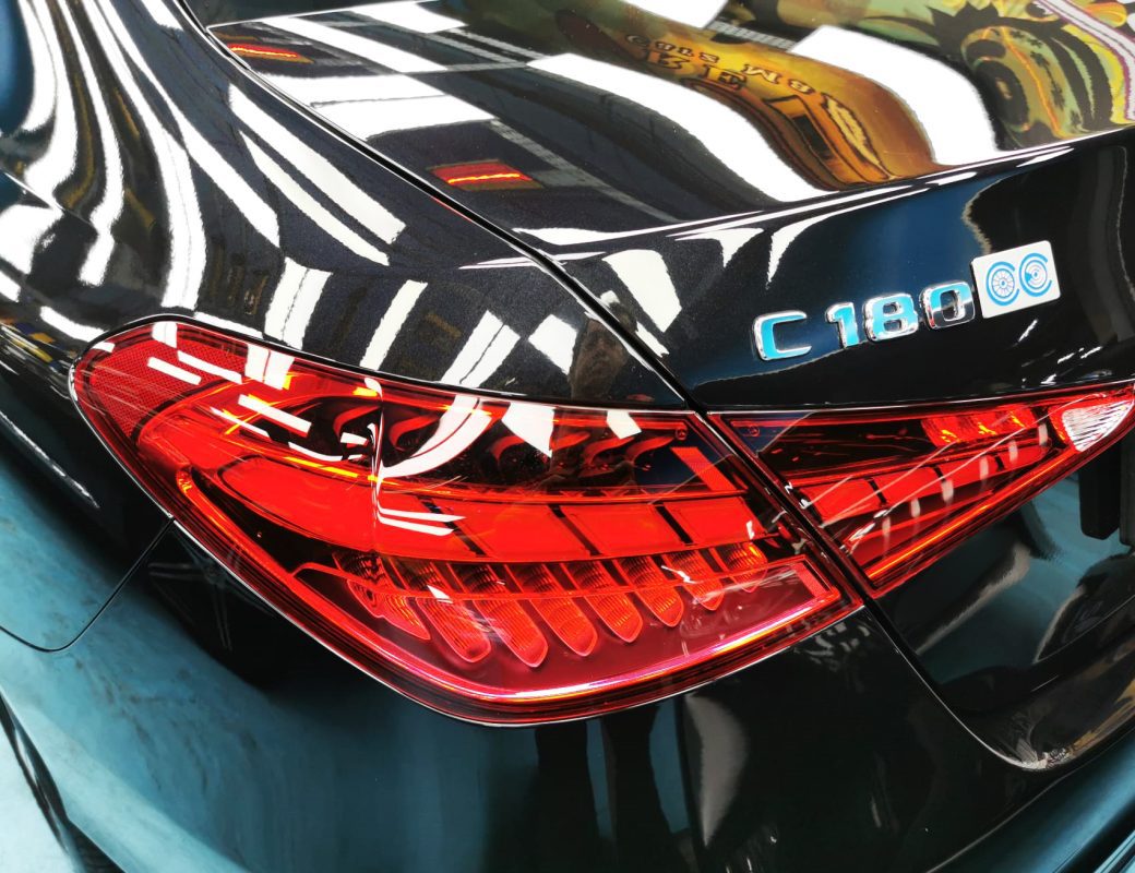 The coated bonnet of the Mercedes-Benz C180 under workshop lighting.