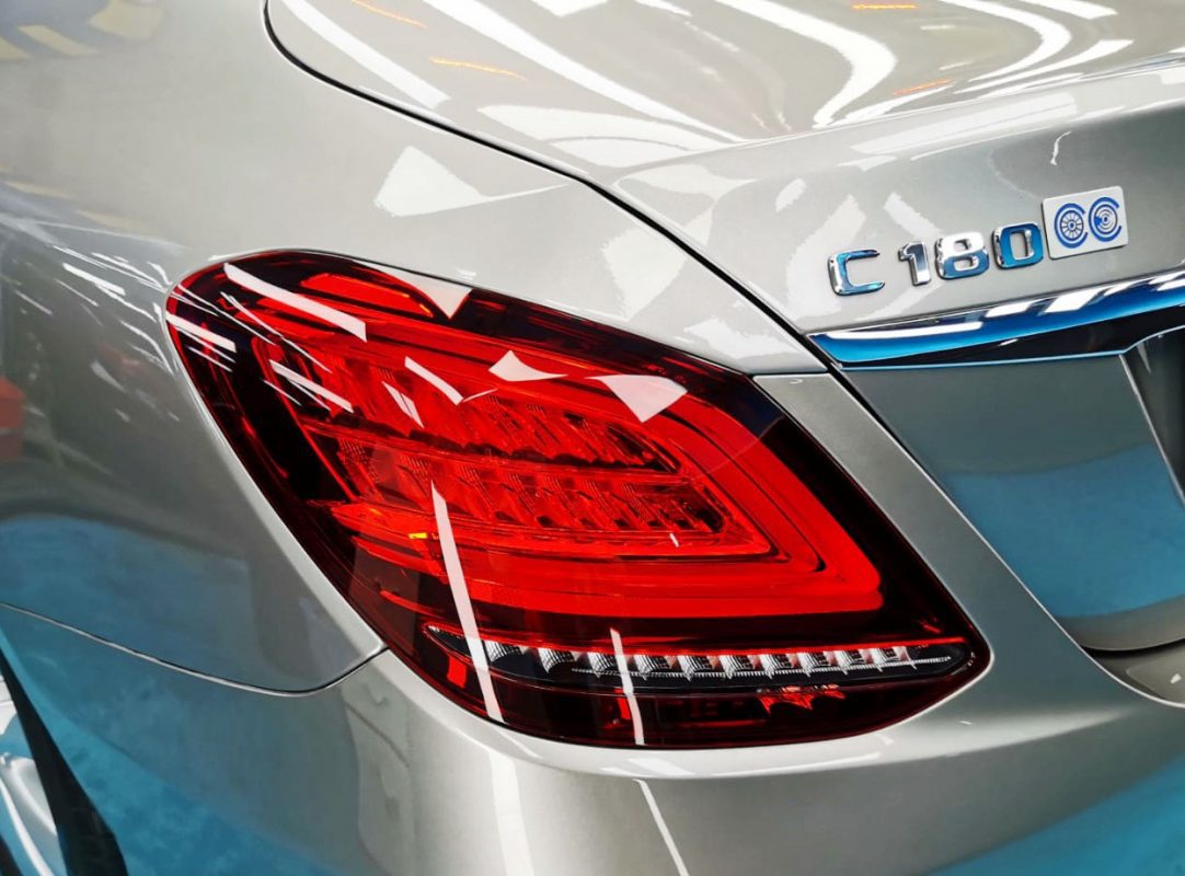 The coated bonnet of the Mercedes-Benz C180 under workshop lighting.
