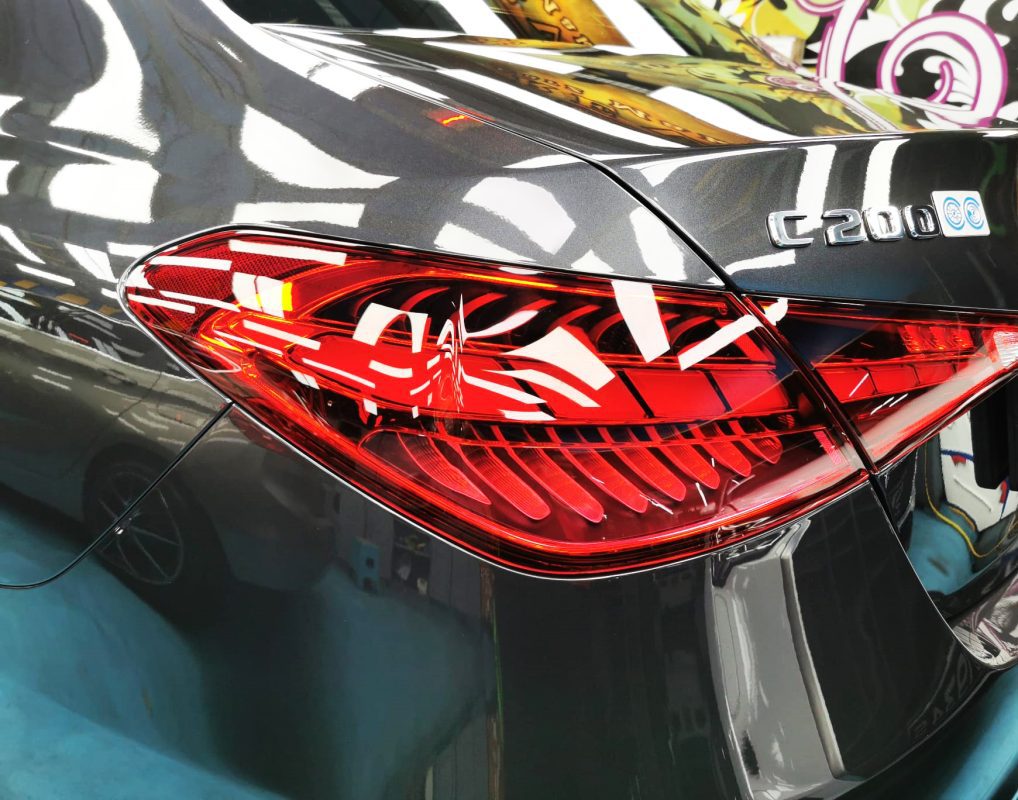 The coated bonnet of the Mercedes-Benz C200 under workshop lighting.