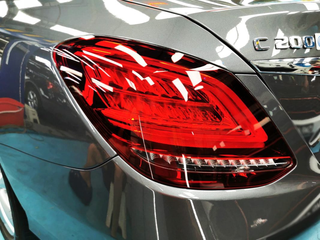 The coated bonnet of the Mercedes-Benz C200 under workshop lighting.