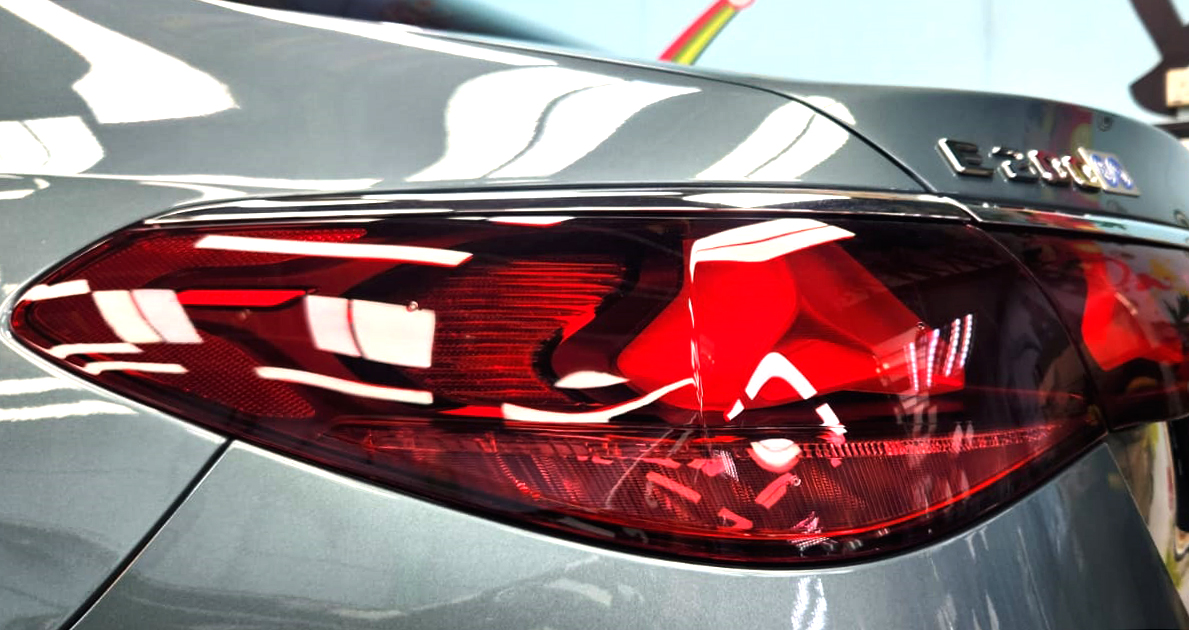The coated bonnet of the Mercedes-Benz C200 under workshop lighting.